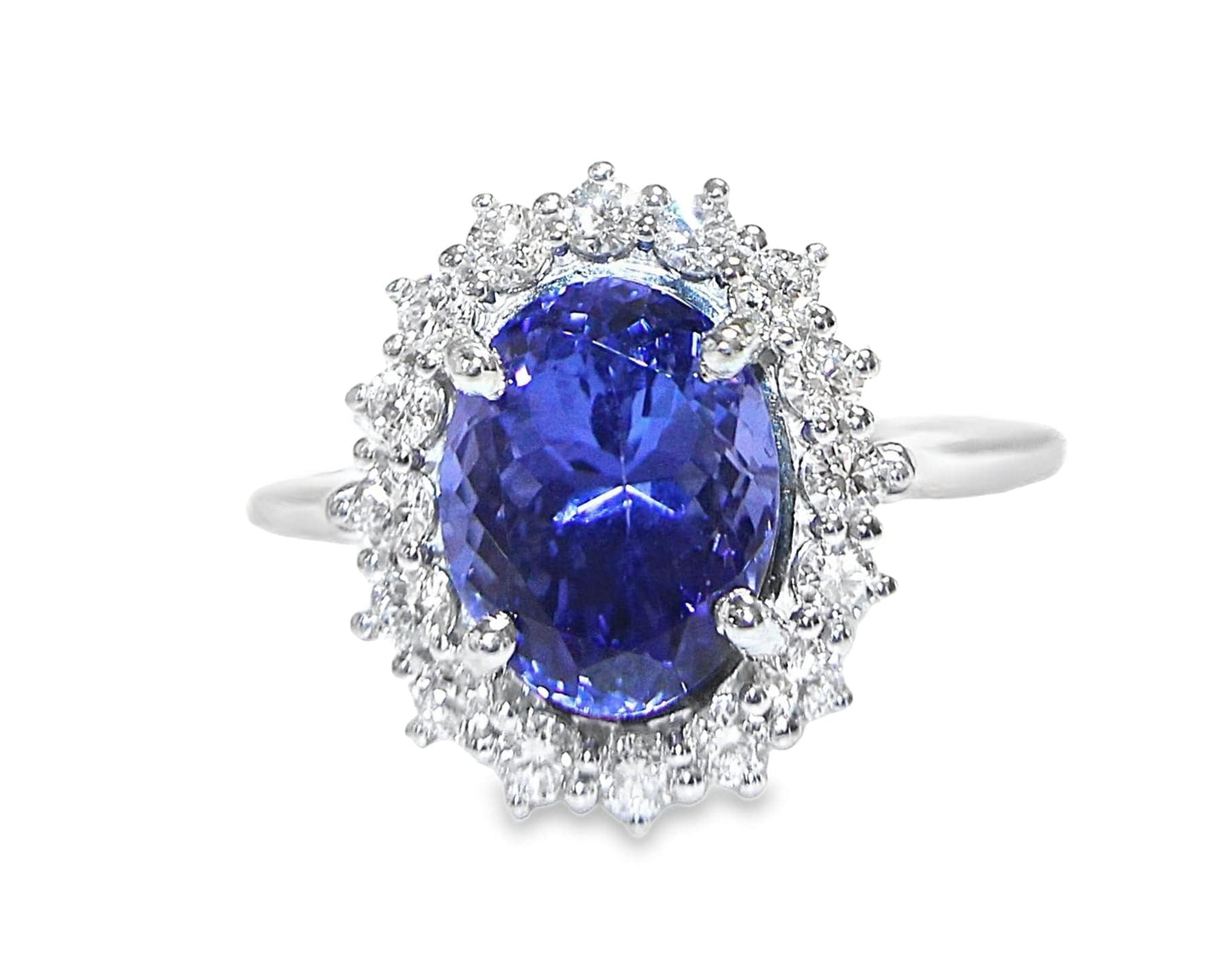10K white gold ring with oval deep blue tanzanite surrounded by round diamond halo.