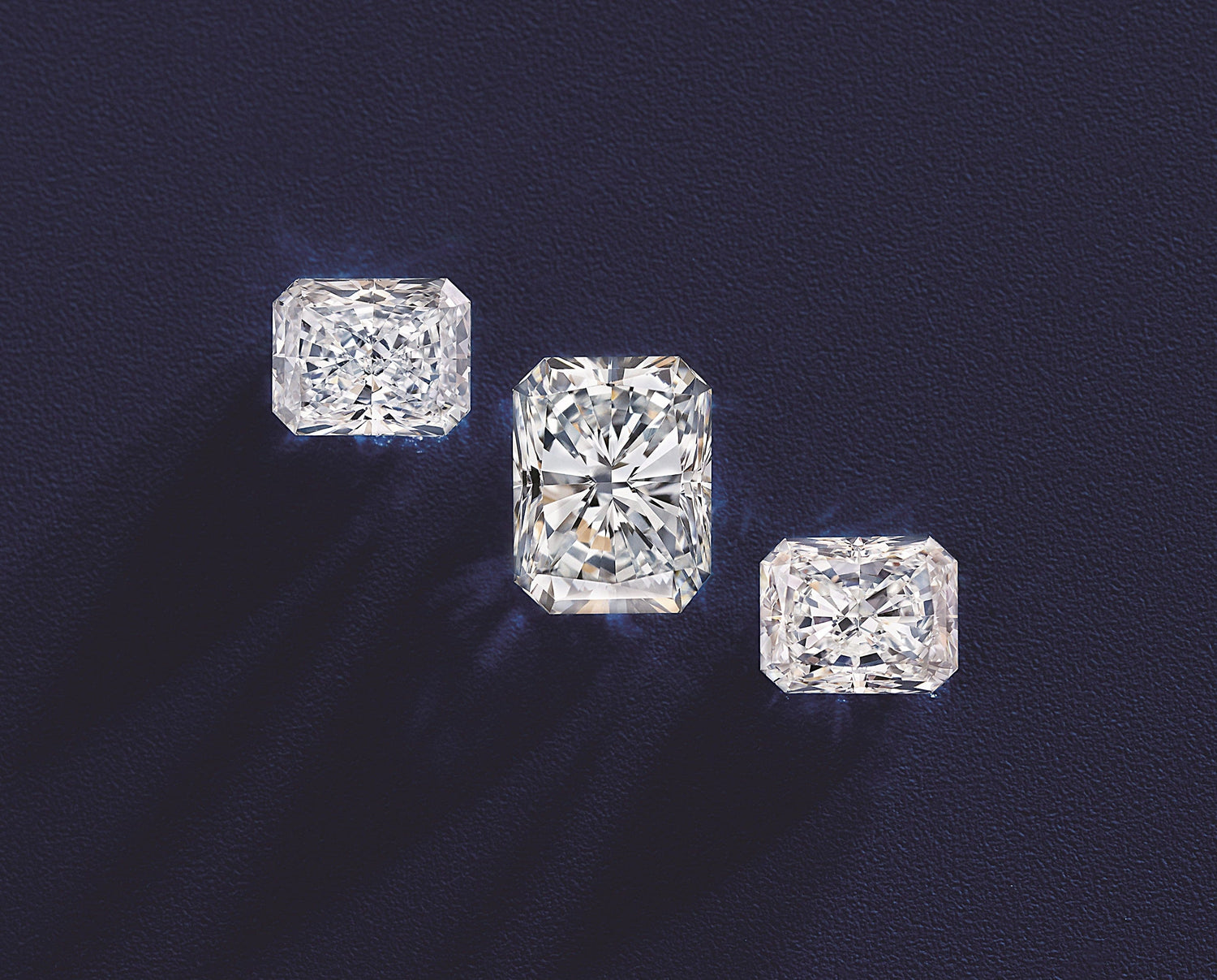 3 radiant cut diamonds on a dark blue background