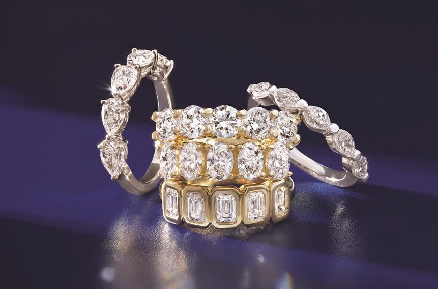 Stacked diamond anniversary bands featuring various cuts and settings, highlighting custom jewelry design and in-house consultation.