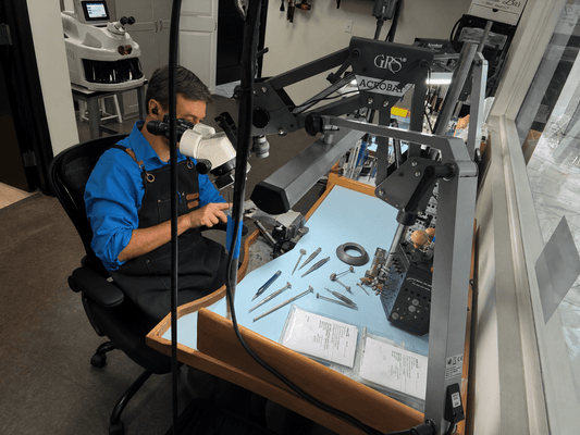 Master jeweler performing jewelry repair under a microscope at Christopher Fine Diamonds in Chandler, Arizona