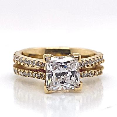 This engagement ring features a .60 CTW CZ center stone in a stunning large square-cut design, set in 14K yellow gold. The elegantly encrusted band with smaller CZ stones makes this piece of jewelry truly timeless.