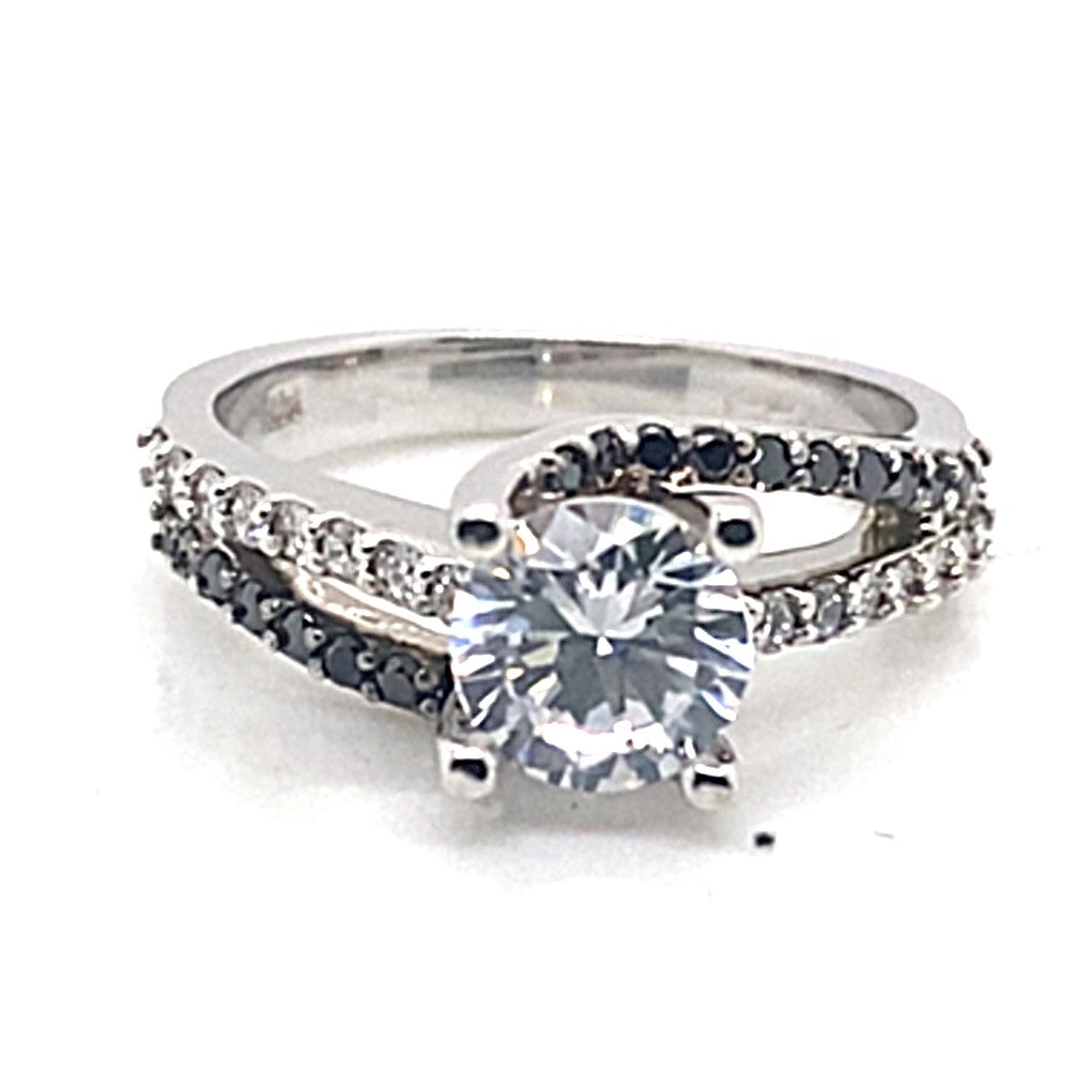 This exquisite 14K white gold ring showcases a stunning 6.5mm RBC CZ center stone and is accented with .19 ct tw natural white diamonds and .18 ct tw natural black diamonds on the band.