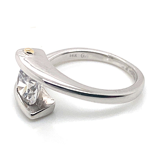 Discover the 14K White Gold Ring with Yellow Gold Bar, showcasing a distinctive channel set bypass design and a striking 6.5mm round CZ center. Perfect for an elegant engagement or any special occasion.