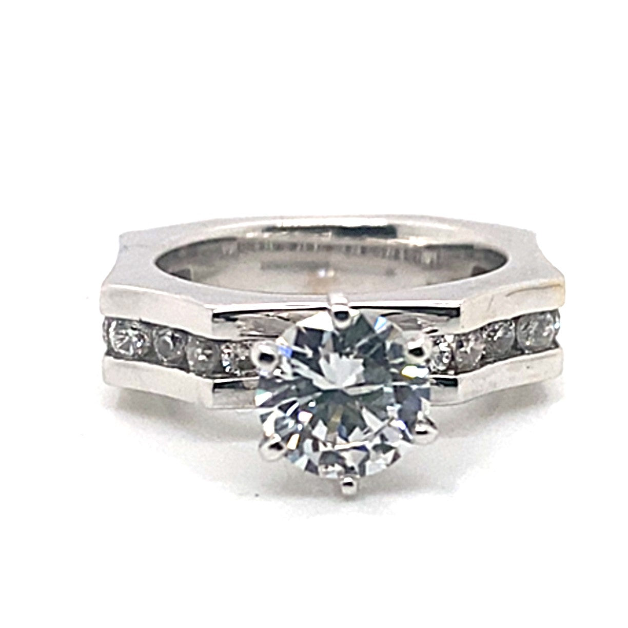 The 14K white gold ring with a concaved octagon style showcases a 6.5 mm round brilliant cubic zirconia center stone, enhanced by natural diamond accents totaling 1/2 carat in a channel setting along the band.