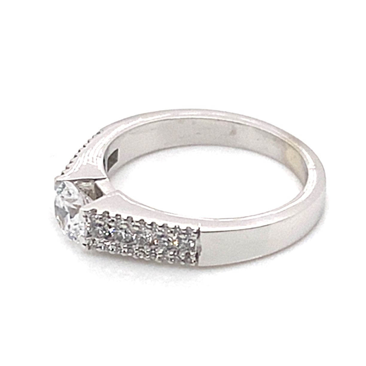 A breathtaking engagement ring made from 14K white gold, showcasing a central 5.5mm RBC cz and accentuated by .35 ct natural round brilliant diamonds along the band.