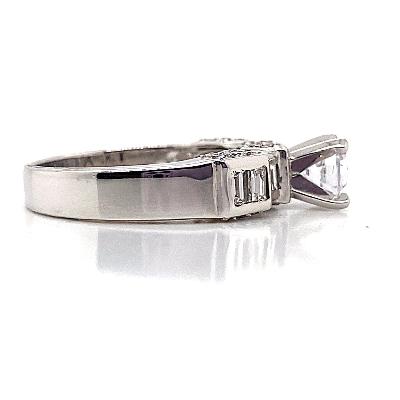 Platinum engagement ring with a 6 mm round brilliant cut cubic zirconia center stone, accented by two natural baguette diamonds totaling .30 carats, elegantly set in a channel setting along the band.