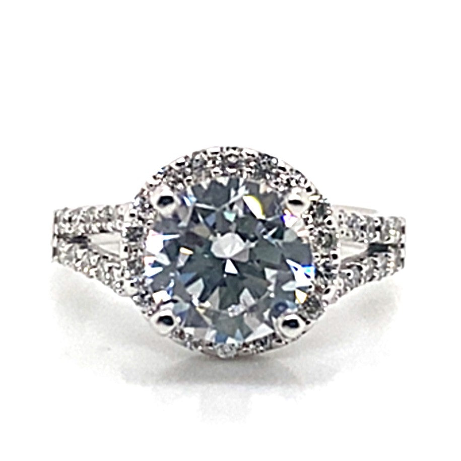 Elegant in design, this 14K white gold ring features an 8 mm oval CZ center stone, beautifully accented by natural round brilliant diamonds that adorn the split shank halo-style band.