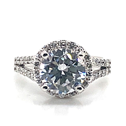 Elegant in design, this 14K white gold ring features an 8 mm oval CZ center stone, beautifully accented by natural round brilliant diamonds that adorn the split shank halo-style band.