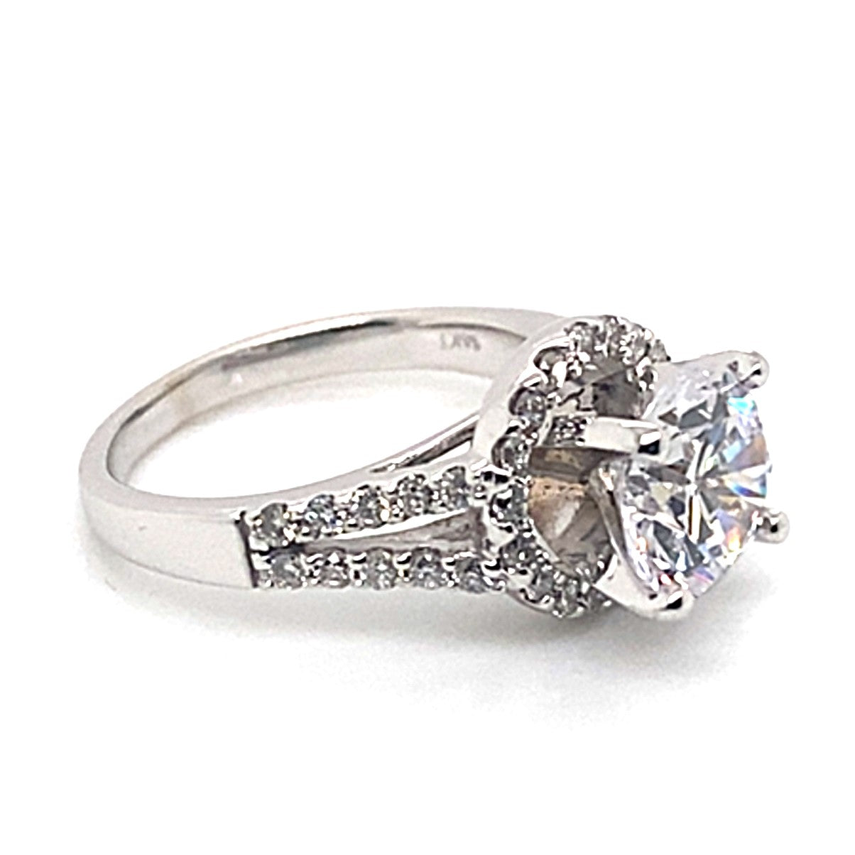 This 14K white gold split shank halo style ring perfectly combines sophisticated design with radiant elegance, showcasing an 8 mm oval CZ center surrounded by dazzling .70 ct TW natural round brilliant diamond accents delicately set along the band.