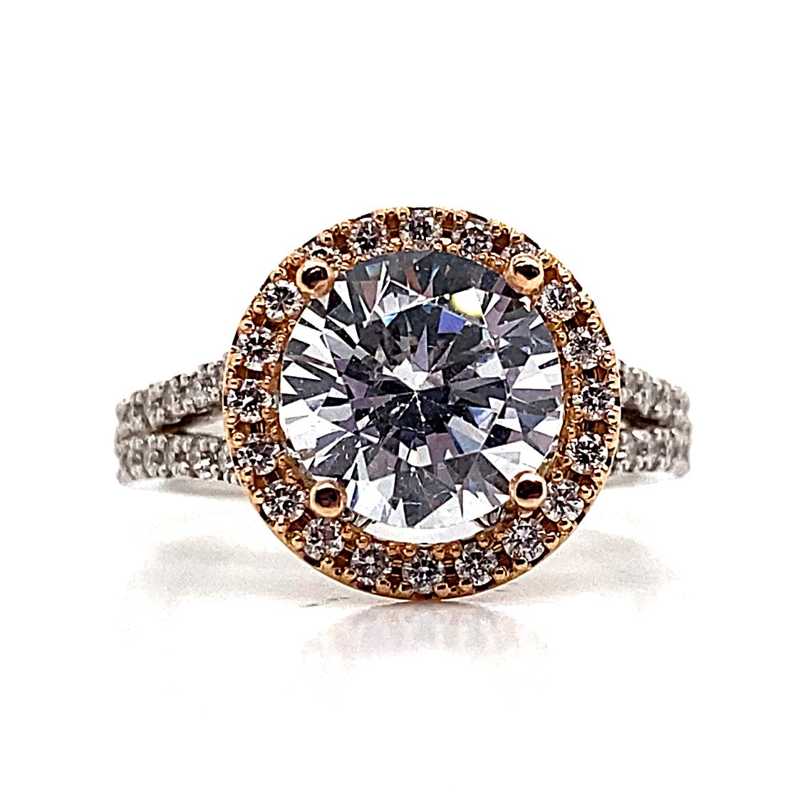 The 14K white gold ring with a rose gold halo showcases a prominent 9mm round brilliant CZ center stone, encircled by a total of 1.10 ct natural round brilliant diamond accents, all elegantly positioned on a split shank band.