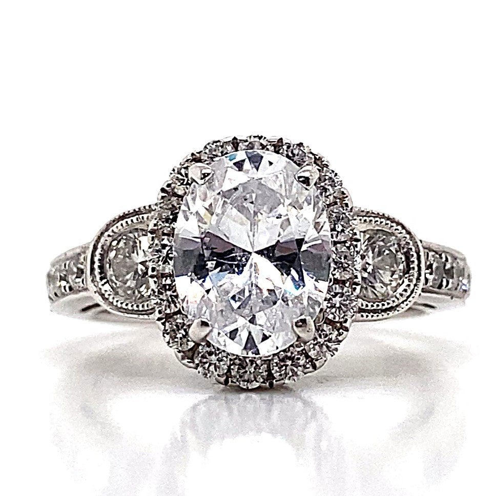 Stunning 14K white gold engagement ring showcasing an oval CZ center stone, enhanced by a halo design of natural round brilliant diamond accents.