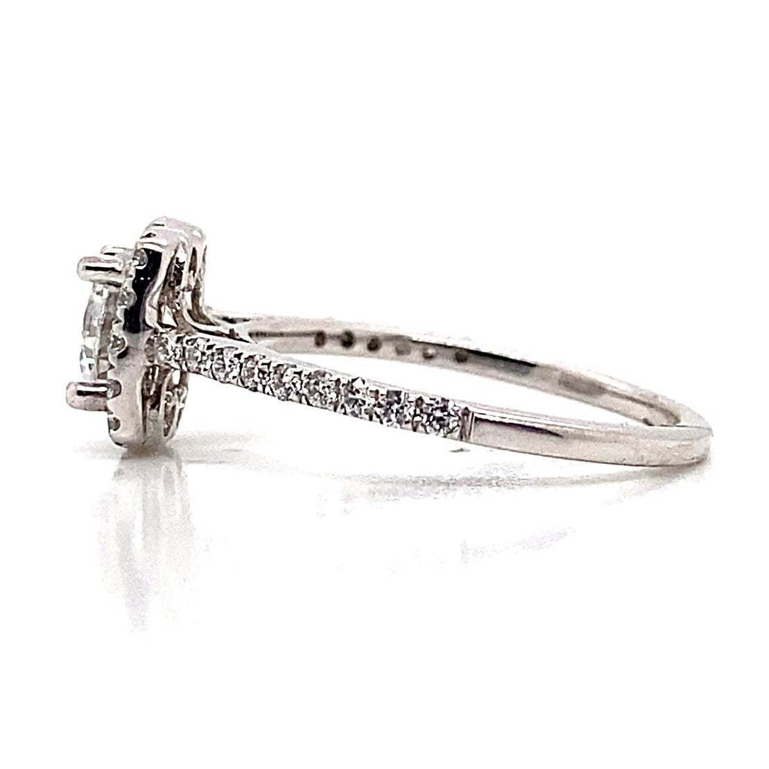 Side view of the exquisite 14K white gold engagement ring showcasing a dazzling 6.5mm RBC CZ center stone, elegantly highlighted by .35 carat total weight of natural round brilliant diamonds in an accent cushion halo style on the band.