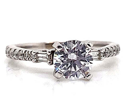 Elegant engagement ring featuring a stunning 6.5mm CZ center stone, flanked by .40 carat total weight of natural baguette and round brilliant diamond accents on a delicate 14K white gold band.