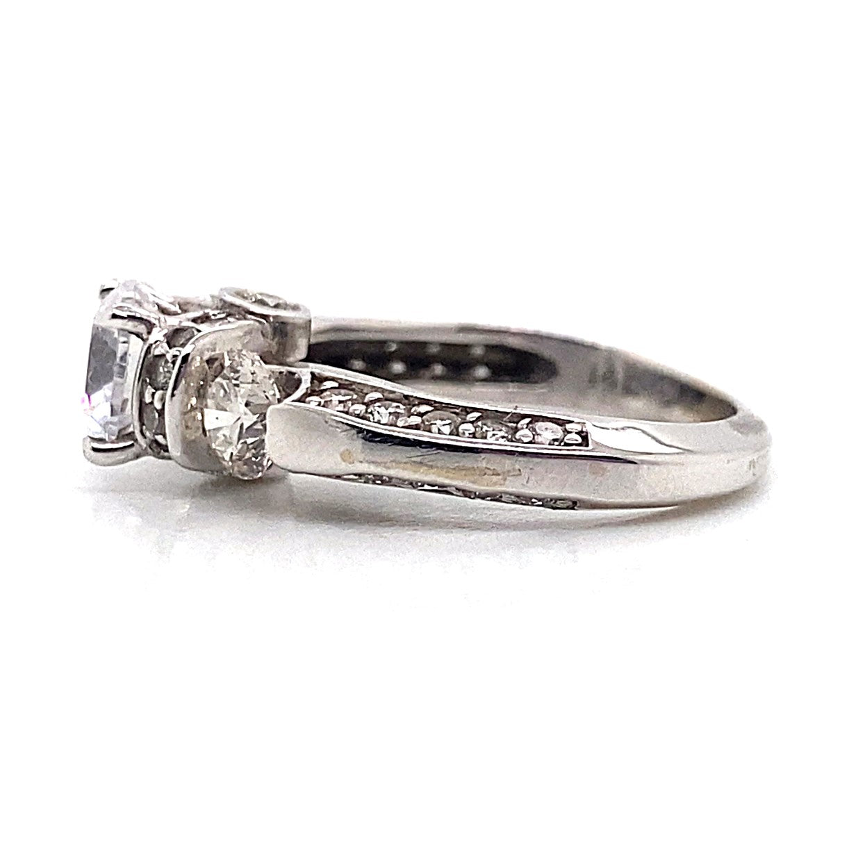 14K white gold engagement ring featuring a 7 mm RBC CZ center stone, accented by two natural round brilliant diamonds and small diamonds adorning the band in a three-stone pave style.