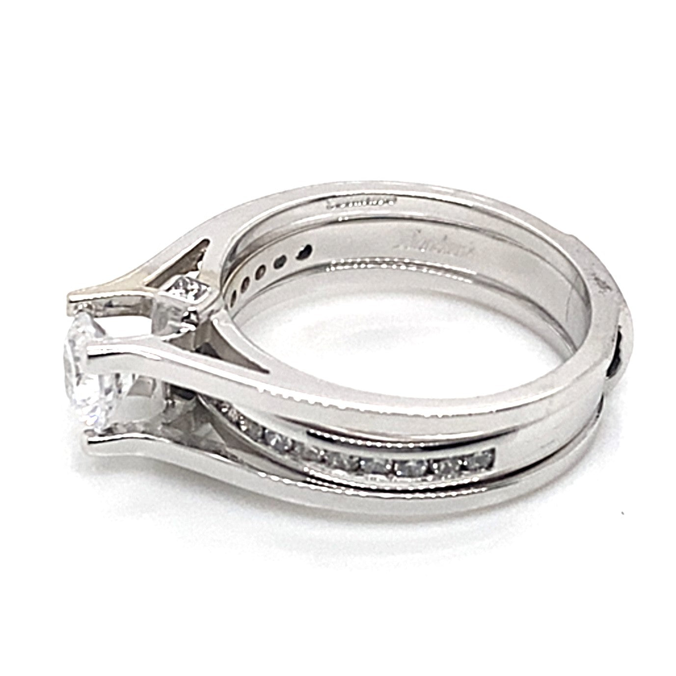 A ring set featuring a 14K white gold engagement band with a 5.25mm round CZ center and .30 ct tw natural diamond accents, paired with an interlocking wedding band, is set on a white background.