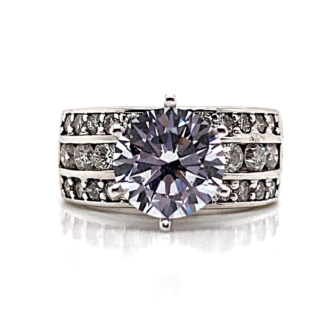 A breathtaking 14K white gold ring adorned with an 8mm RBC cubic zirconia center stone and three rows of natural round brilliant accents set along the band.