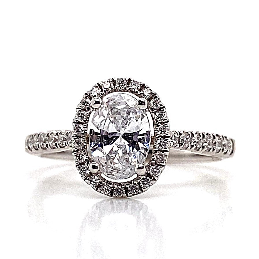 A classic beauty, this 18K white gold engagement ring features a CZ center and .35 CT TW accent halo.