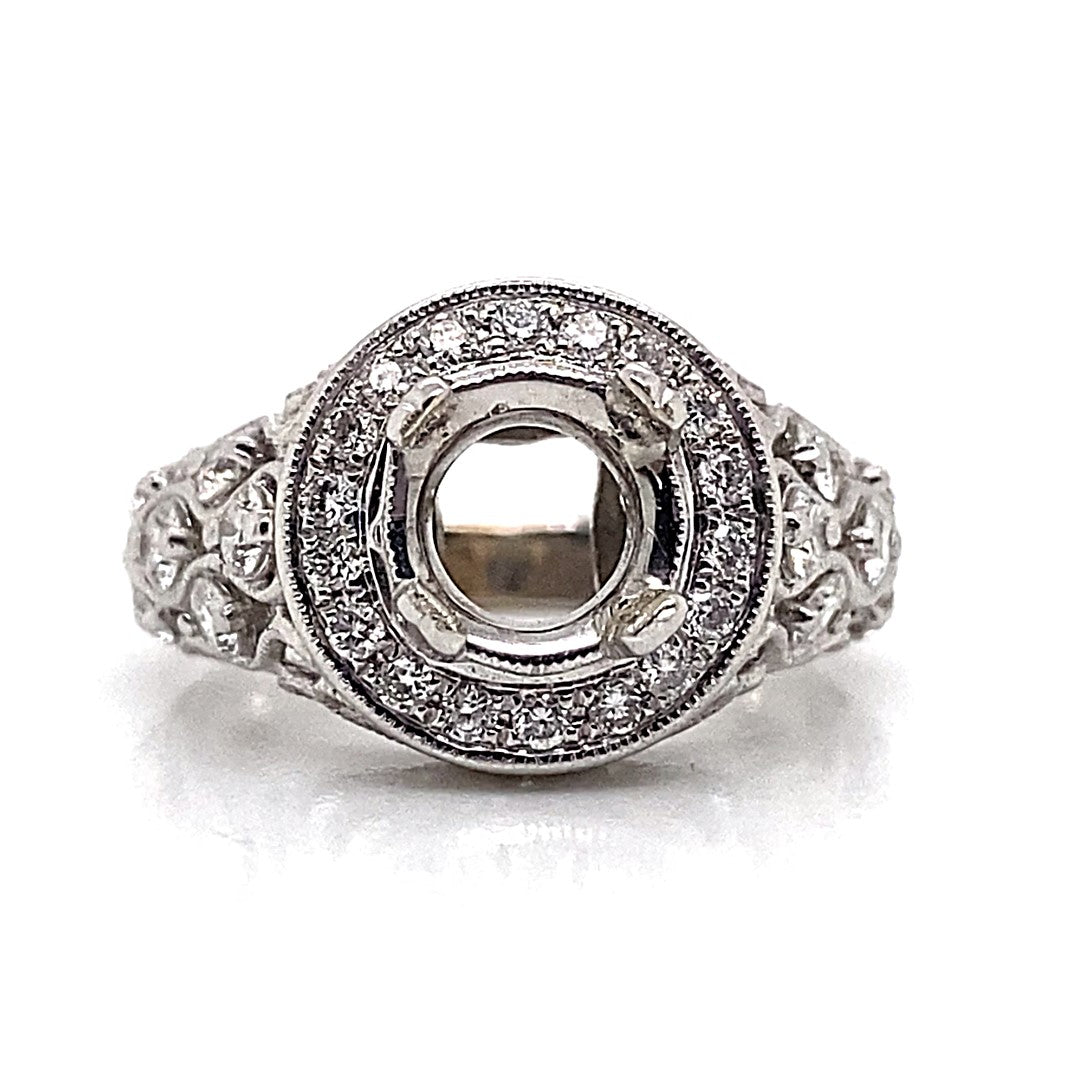 This exquisite engagement ring, named the 18K White Gold No Center (7.5 mm RBC), features .60 carats total weight of natural round brilliant diamond accents in a unique custom halo style, and is crafted from 18K white gold with an empty round setting for the centerpiece gem.