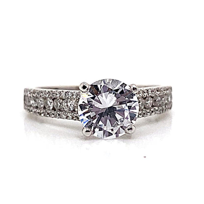 An 18K white gold ring with a 7mm CZ center, .80 ct tw natural round brilliant diamond accent in a three-row style.