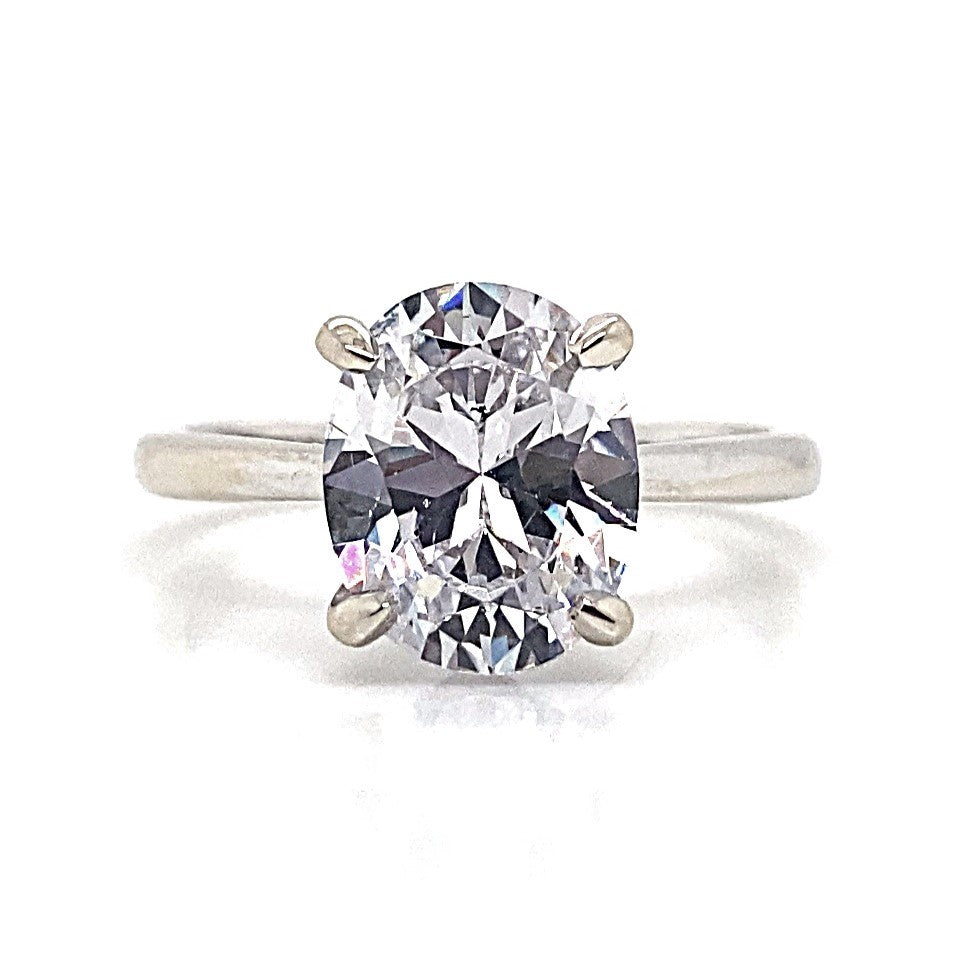 A solitaire ring crafted from exquisite 14K white gold features a large, oval-shaped CZ centerpiece in an elegant four-prong setting.