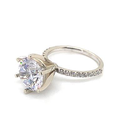 This 14K white gold ring showcases a captivating large round CZ center (10mm RBC) accentuated by 1/5 carat total weight of natural round brilliant diamond accents along the band.