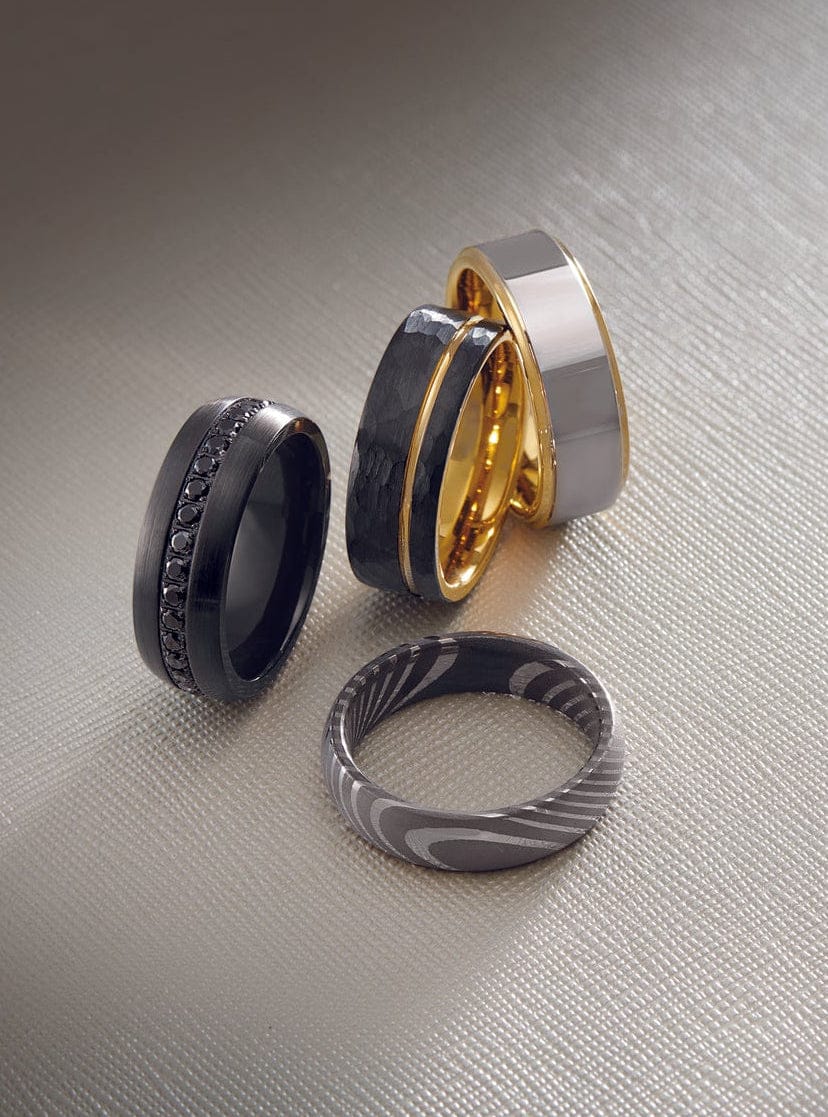 multiple modern mens wedding bands laying on a table