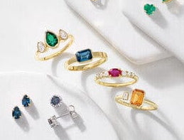 Set of colorful gemstone rings on a white surface