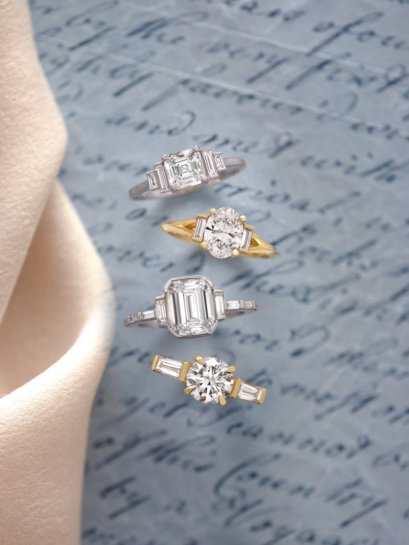 Set of trending engagement rings on a textured surface with cursive writing
