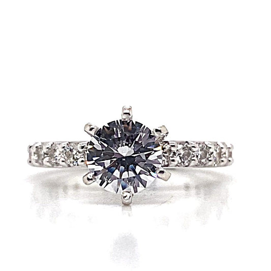 Engagement ring crafted from 14K white gold, highlighted by a 6.5 mm round brilliant cut CZ center stone, surrounded by natural diamond accents totaling 3/4 carat, elegantly set on a diamond-encrusted band against a pristine white background.