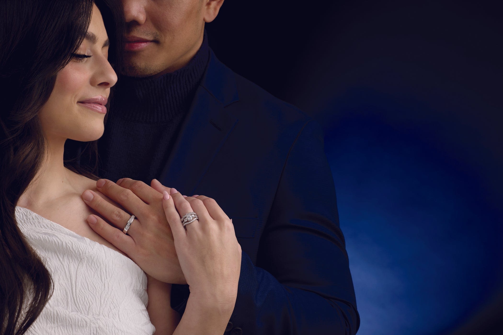 Couple holding hands with a dark blue background