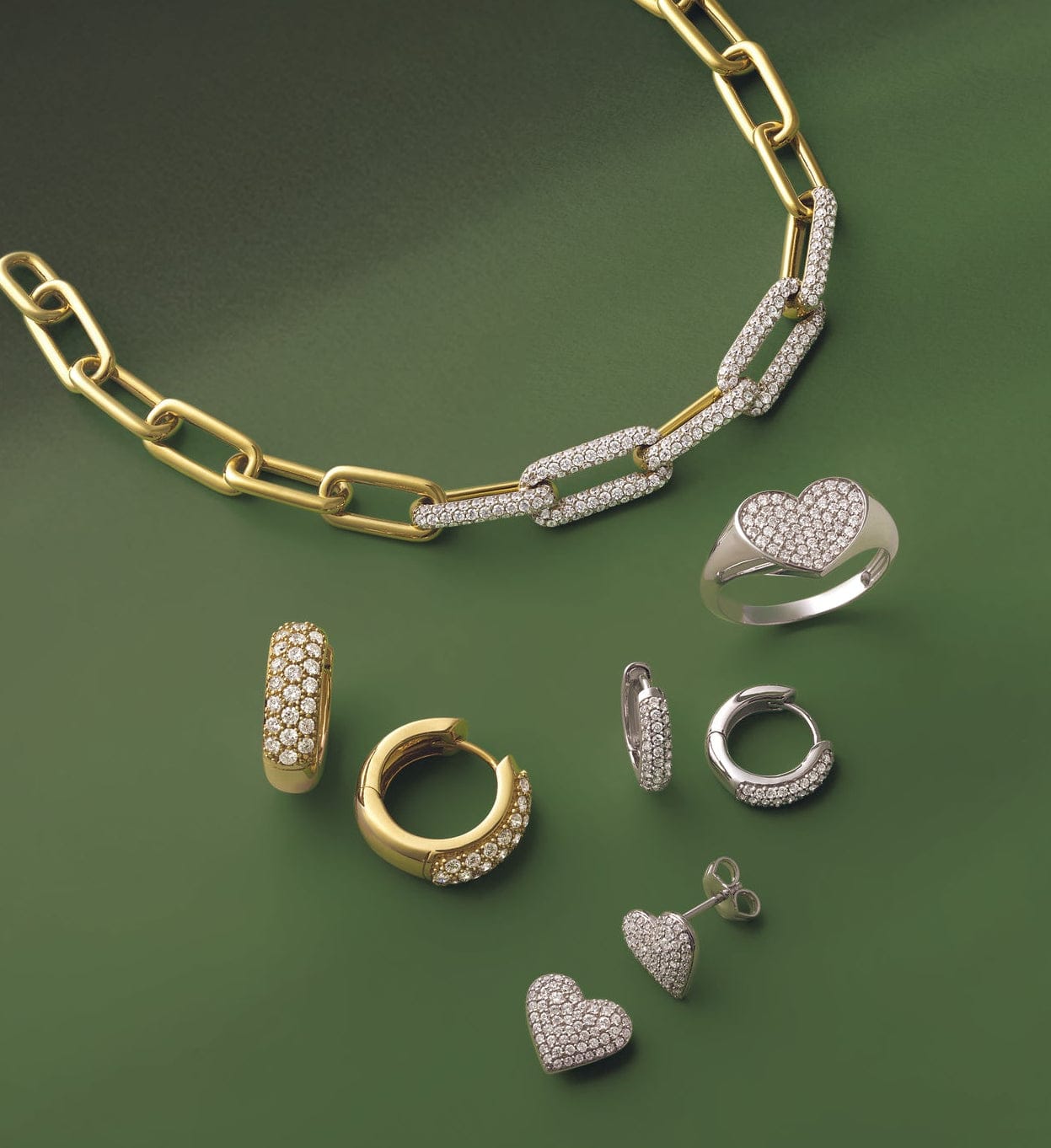 Gold and silver fashion jewelry and fashion earrings set on a green background