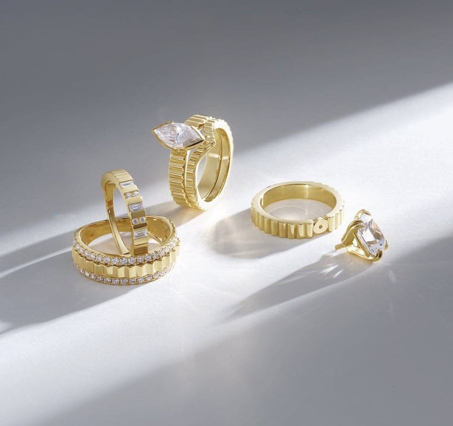 Gold engagement rings with diamonds on a light gray background