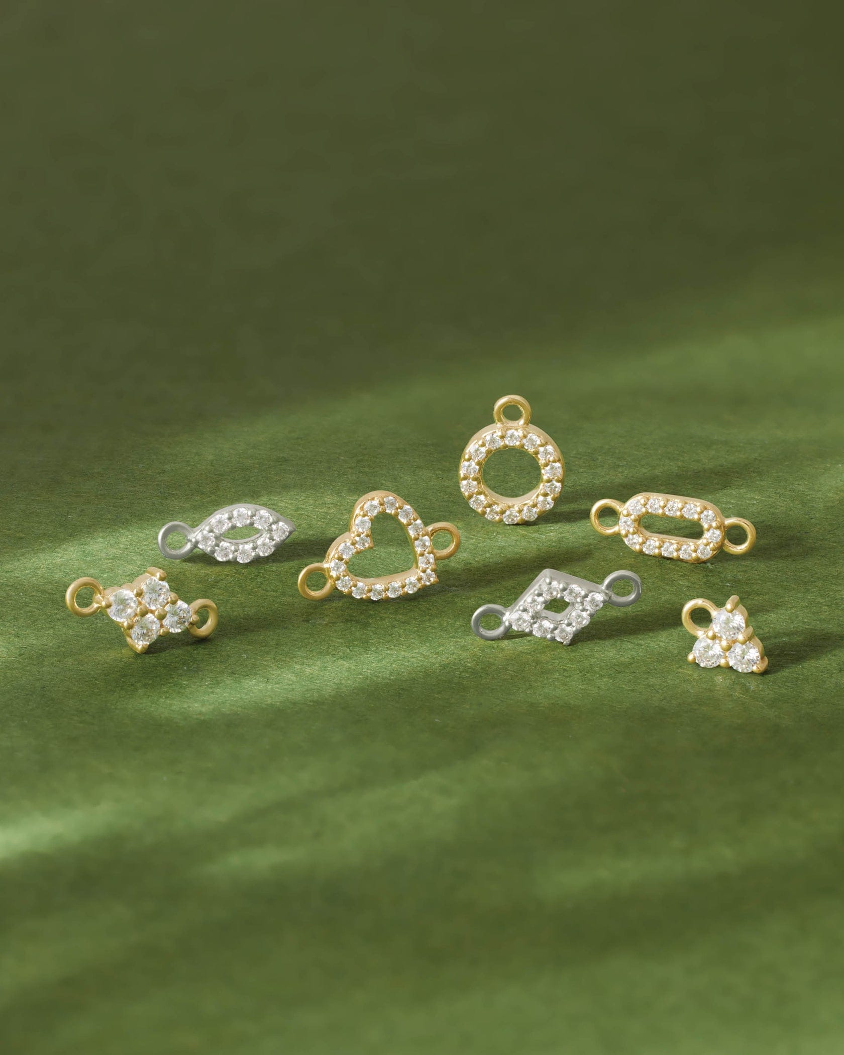 collection of diamond  pendants on a green surface