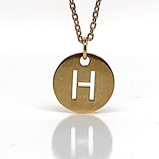 This exquisite personalized jewelry piece is the 14K Yellow Gold "H" Disc Style Pendant with Chain, showcasing a round yellow gold disc adorned with the letter H on a pristine white background. Crafted from 14K yellow gold, it seamlessly blends elegance and personal flair.