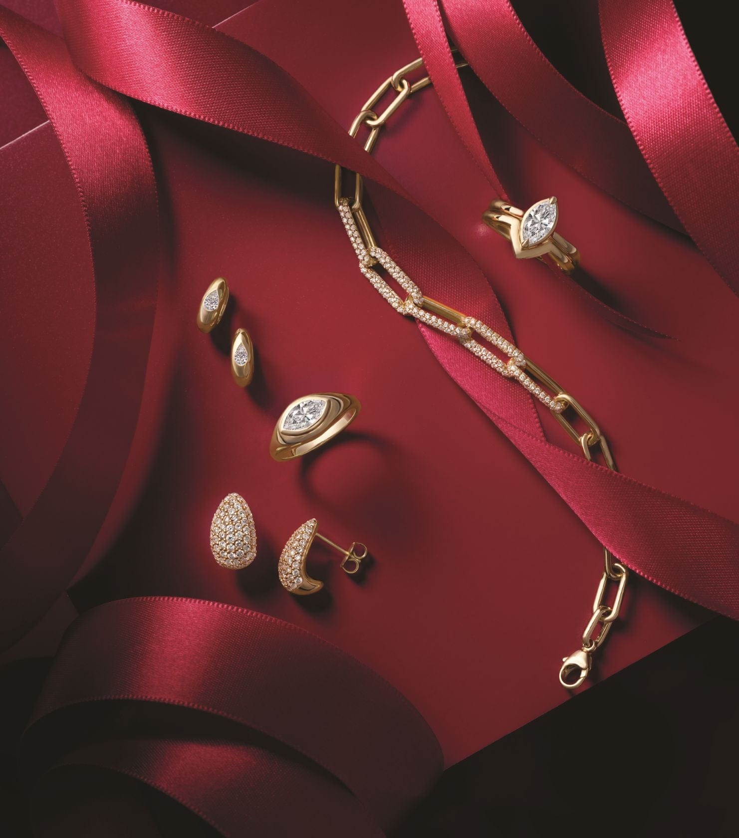 14k Gold jewelry set including earrings and a necklace on a red fabric background