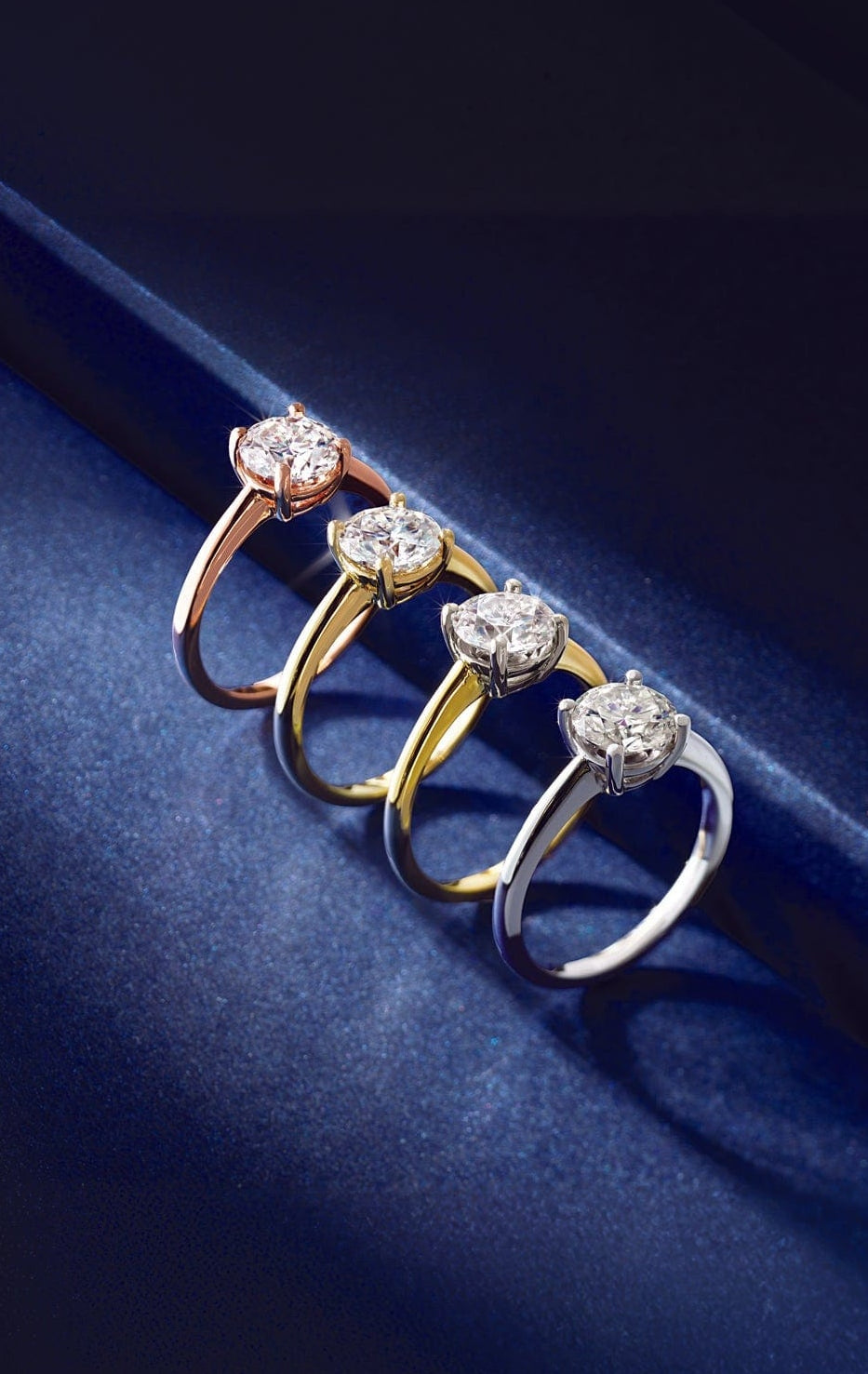 Set of four diamond rings on a dark blue surface