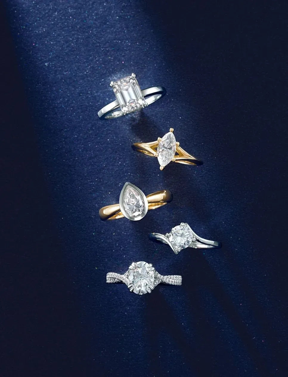 Five diamond engagement rings displayed on a dark blue background