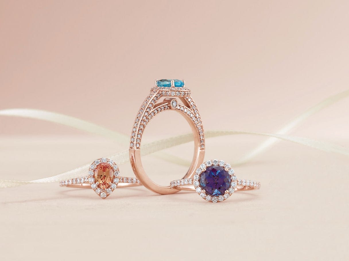 Rose gold ring with gemstones on a pink background