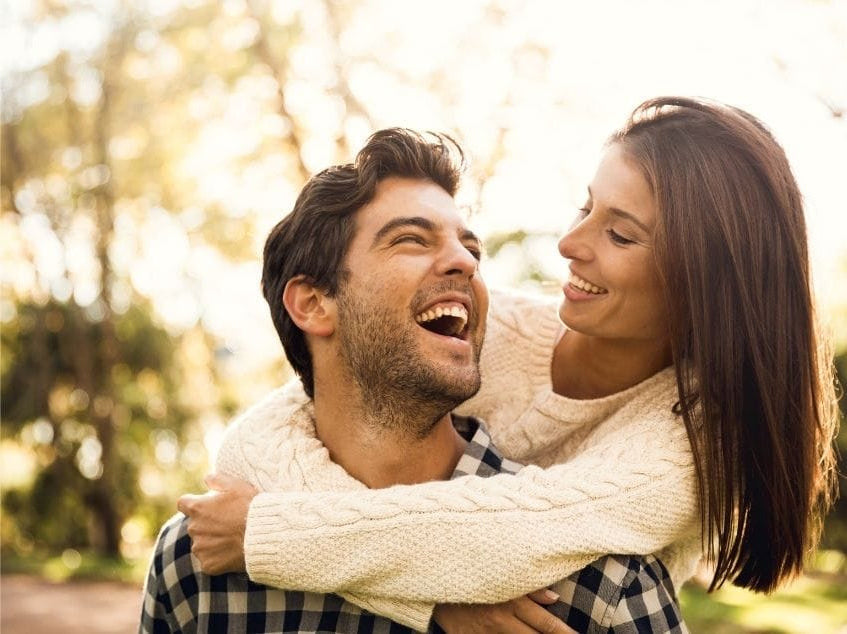 Man and woman laughing together in a park