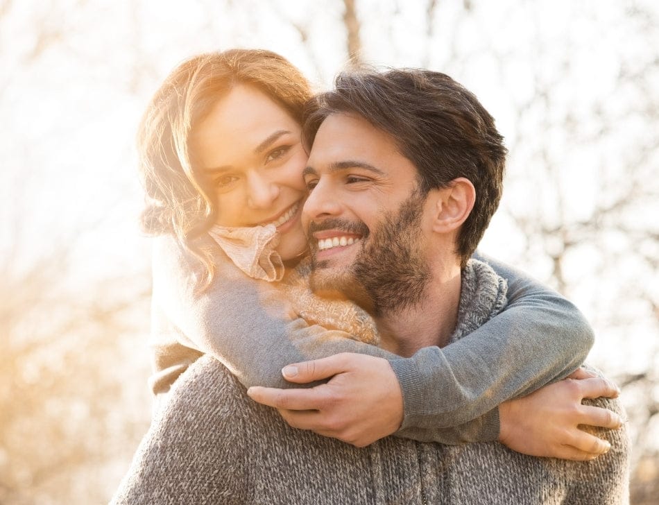 Couple hugging outdoors with a warm, golden light