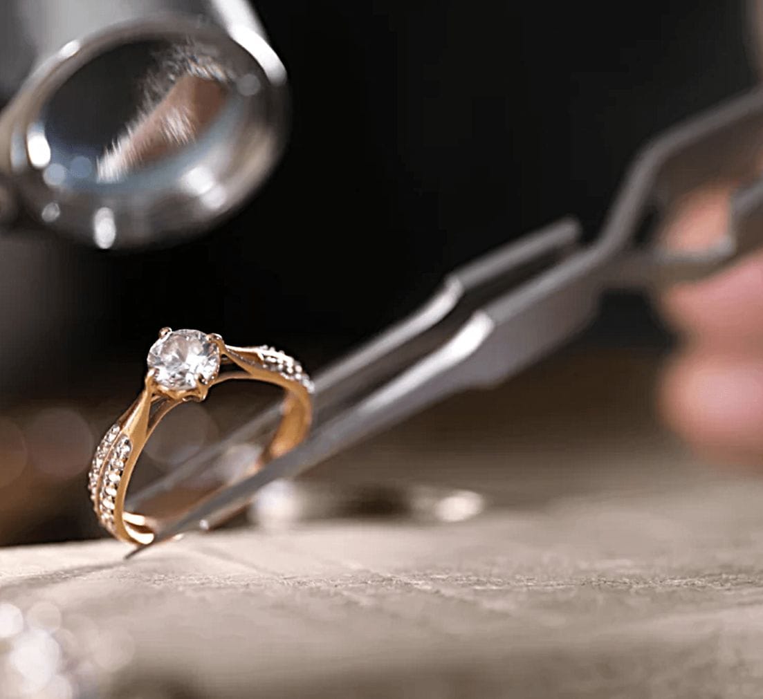 PHOTO OF RING BEING HELD BY TWEEZERS