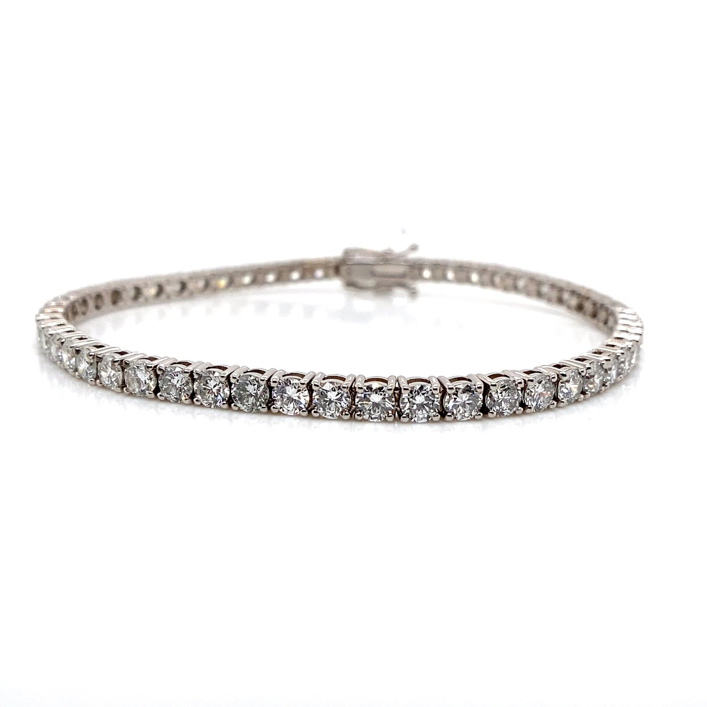 A 14K White Gold Tennis Bracelet adorned with 6.02 carats of lab-grown diamonds on a white background, radiating an aura of elegance.