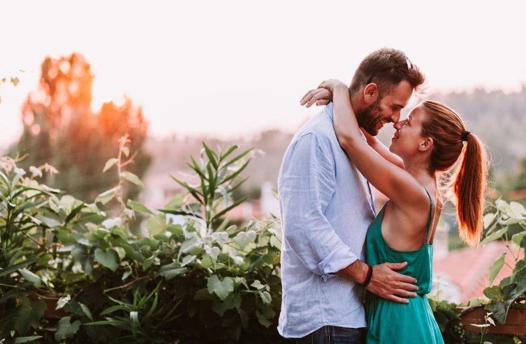 Couple embracing in a garden with a blurred background
