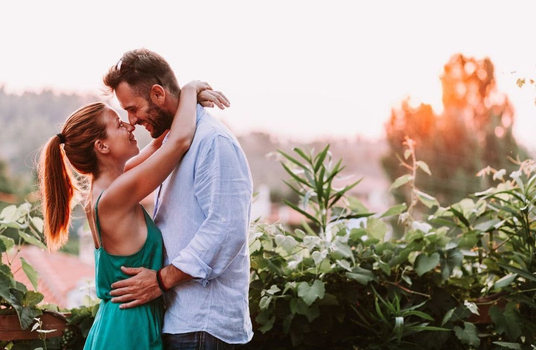 Couple embracing in a garden with a blurred background