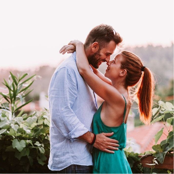 Couple embracing in a garden with a blurred background