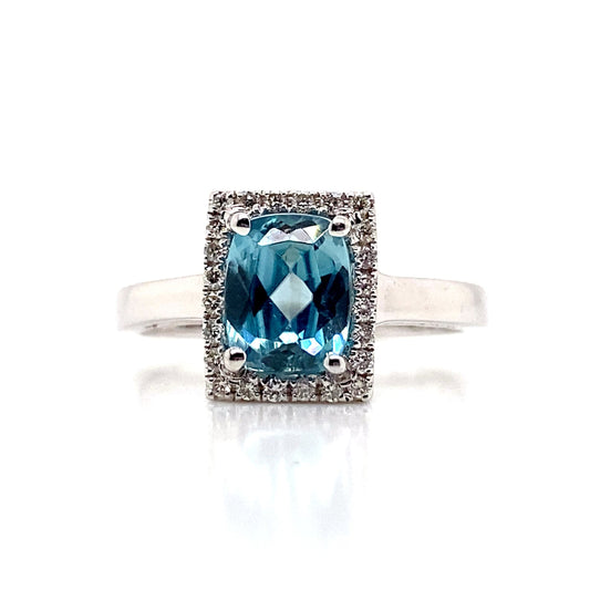 The 14K White Gold ring showcases a captivating 1.78 ct Blue Zircon gemstone surrounded by a rectangular halo of sparkling natural diamond accents totaling 0.14 tw, elegantly set on a sleek band.