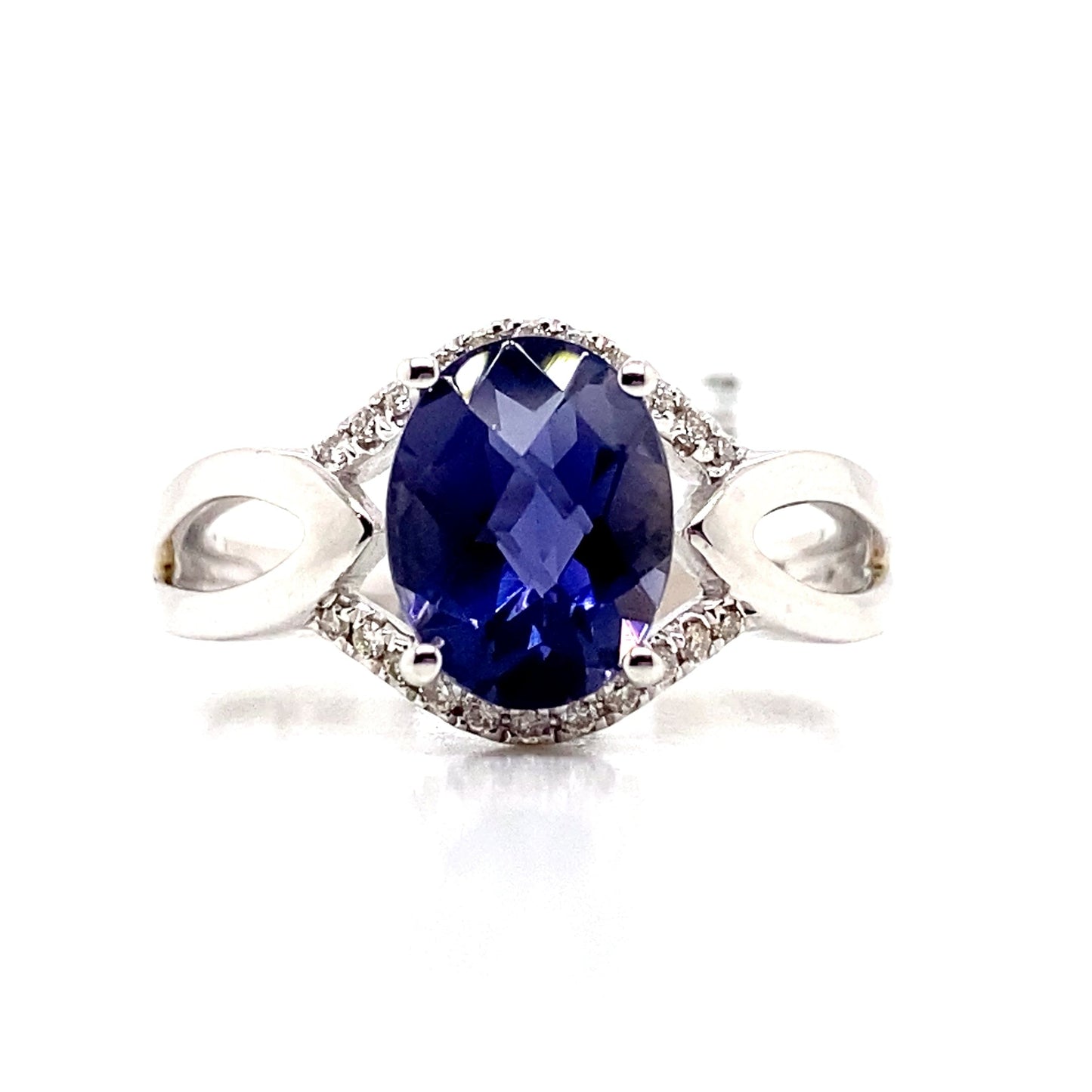 A 14K white gold ring showcasing a 1.85 ct oval Iolite center stone with natural diamond accents totaling 0.132 tw, offering unique elegance.