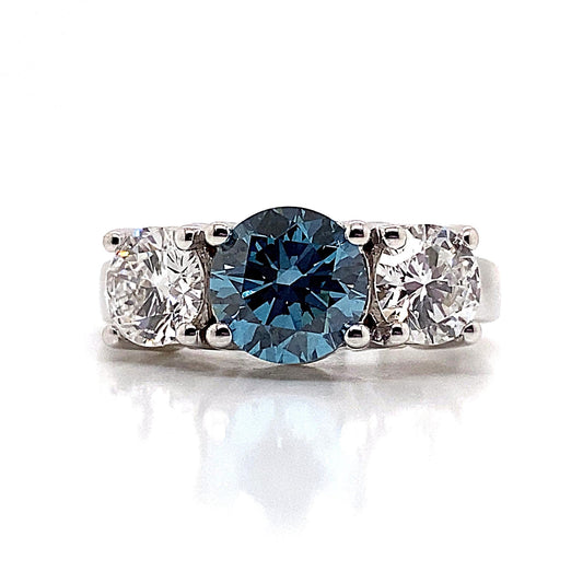 A 14K white gold ring showcasing a central blue lab-grown diamond, complemented by two additional lab-grown diamonds in a stunning three-stone design.