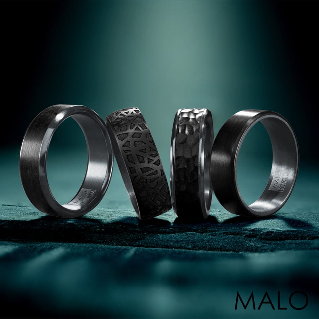Four textured black rings stand upright on a dark surface with MALO logo in the bottom right corner.