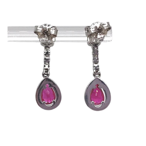 The 18K white gold drop earrings, featuring a stunning .80 carat natural pear ruby at the center and adorned with .55 carats of round brilliant diamonds, create an enchanting blend of sophistication and charm reminiscent of elegant floral studs.